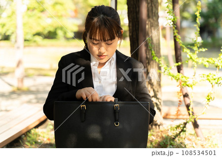 ベンチで休憩するスーツの女性 108534501