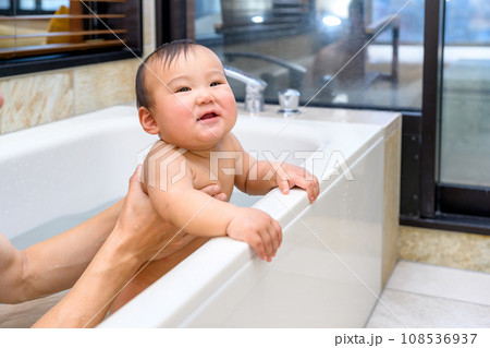 父親にお風呂に入れてもらう赤ちゃん　笑顔喜ぶ　乳幼児　イクメン　育児休暇　0歳乳幼児　浴槽バスルーム 108536937