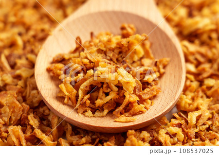 Crispy fried onions in wooden spoon. Roasted golden shallot flakes. Crispy fried onions in wooden spoon. Roasted golden shallot flakes. 108537025
