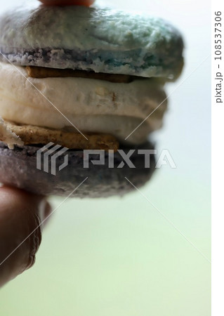 水色のクリームチーズトゥンカロンを持つ手 水色のクリームチーズトゥンカロンを持つ手 108537306