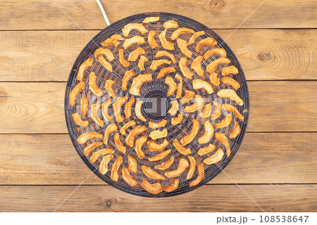 Top view of an open dryer for vegetables and fruits with dried apples. Top view of an open dryer for vegetables and fruits with dried apples. 108538647