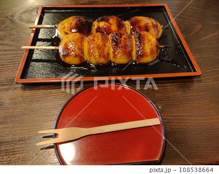 上州名物のおいしそうな二種類の焼きまんじゅうが二本テーブルの上に置かれている 上州名物のおいしそうな二種類の焼きまんじゅうが二本テーブルの上に置かれている 108538664