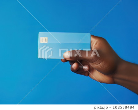 Male hand holding a blue bank card on a blue background AI 108539494