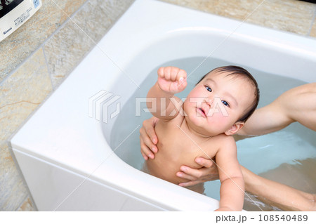 父親にお風呂に入れてもらう赤ちゃん　楽しい　乳幼児　イクメン　育児休暇　0歳乳幼児　浴槽ガッツポーズ 108540489