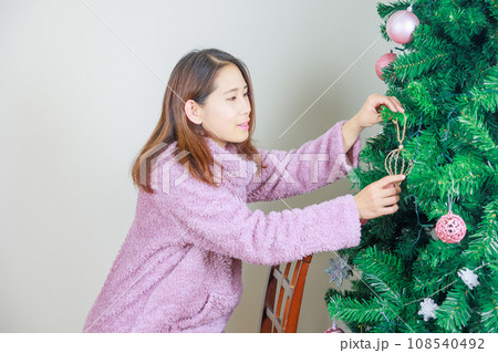 クリスマスツリーの飾り付けをする女性 クリスマスツリーの飾り付けをする女性 108540492