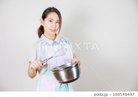 白い背景に日本女性性がボウルと泡立て器で料理する 白い背景に日本女性性がボウルと泡立て器で料理する 108540497