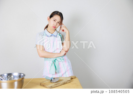 キッチンで考えるエプロン姿の女性 108540505