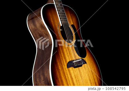 Mahogany Acoustic Guitar Isolated Upright on a Black Backgound 108542795