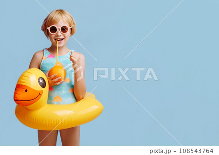 Child with inflatable duck ring on blue background with copy space. Child with inflatable duck ring on blue background with copy space. 108543764
