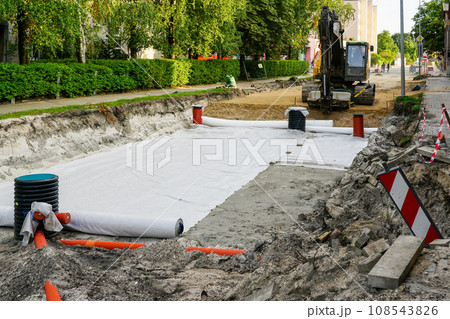 Use of geotextile fabric rolls for drainage and separation of base layers in street reconstruction 108543826