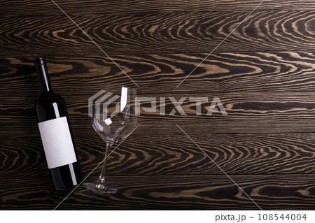 Glass and bottle with red wine on rustic background. Flat lay Glass and bottle with red wine on rustic background. Flat lay 108544004