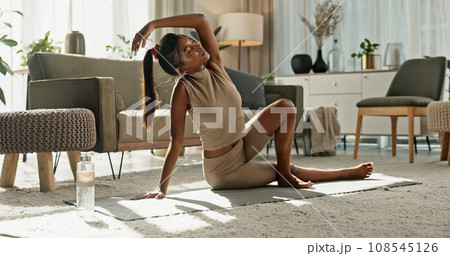 Woman, stretching or relax with yoga on living room floor, exercise or fitness at home. Indian, young person or workout with flexible body or pilates, healthy or balance for wellness by water bottle 108545126