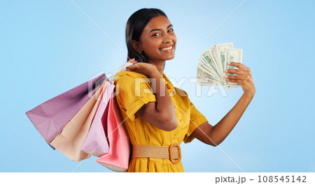Woman, shopping bag and cash fan, wealth and commerce with customer in portrait on blue background. Money, financial freedom and retail, fashion and product choice, rich and store discount in studio Woman, shopping bag and cash fan, wealth and commerce with customer in portrait on blue background. Money, financial freedom and retail, fashion and product choice, rich and store discount in studio 108545142