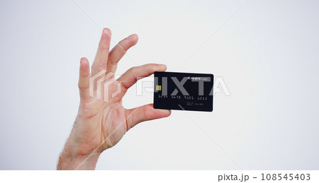 Hand, money and closeup of credit card in a studio for online shopping, paying bills or debt. Ecommerce, payment and zoom of person with bank account for buying products isolated by white background. 108545403