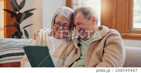 Tablet, laugh and senior couple on a sofa watching a funny, comic or comedy video on social media. Happy, smile and elderly people in retirement scroll on mobile app or internet on digital technology Tablet, laugh and senior couple on a sofa watching a funny, comic or comedy video on social media. Happy, smile and elderly people in retirement scroll on mobile app or internet on digital technology 108545407