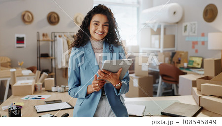 Portrait, boxes and woman with a tablet, ecommerce and smile with connection, internet and delivery with company website. Face, person or employee with technology, shipping or online order with sales Portrait, boxes and woman with a tablet, ecommerce and smile with connection, internet and delivery with company website. Face, person or employee with technology, shipping or online order with sales 108545849