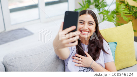 Woman, video call and sofa with smile, home and happy on web blog, internet and relax in living room. Influencer girl, excited and live streaming for memory, contact and social network app on couch Woman, video call and sofa with smile, home and happy on web blog, internet and relax in living room. Influencer girl, excited and live streaming for memory, contact and social network app on couch 108546324