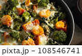 Gratin with broccoli, carrots and cheese baked in the oven on a dark wooden table, close up 108546741