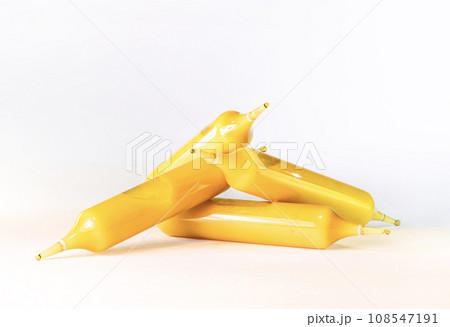 白い背景に金色のローヤル ゼリーが入った小瓶またはアンプルが積み上げられています。 白い背景に金色のローヤル ゼリーが入った小瓶またはアンプルが積み上げられています。 108547191