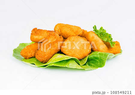 Breaded chicken nuggets. Breaded Chicken Inner Fillet with green lettuce leaves on a White Background,Chicken Breaded Raw Meat,Fillet.Fast homemade food at home.Chicken breaded schnitzels.Fast cooking Breaded chicken nuggets. Breaded Chicken Inner Fillet with green lettuce leaves on a White Background,Chicken Breaded Raw Meat,Fillet.Fast homemade food at home.Chicken breaded schnitzels.Fast cooking 108549211