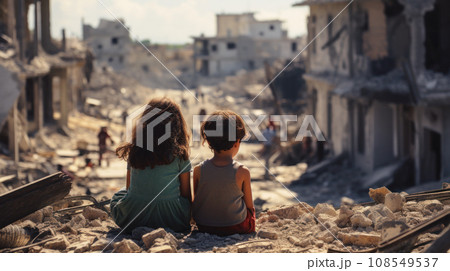 Middle Eastern children in destroyed city, back view. Unhappy Arab kids looks at buildings ruins during war in Israel. Concept of Palestinian Israeli conflict, young people, school 108549537