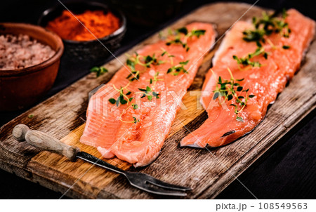 fillet of trout red fish with herbs on a cutting board 108549563