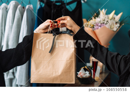 Passing a paper bag from hand to hand in a store 108550558