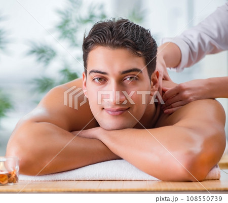 Handsome man during spa massaging session Handsome man during spa massaging session 108550739