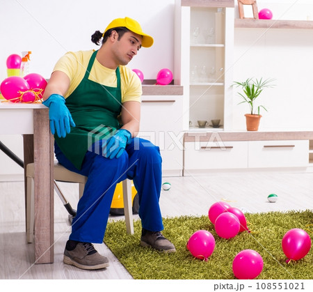Young male contractor doing housework after party 108551021