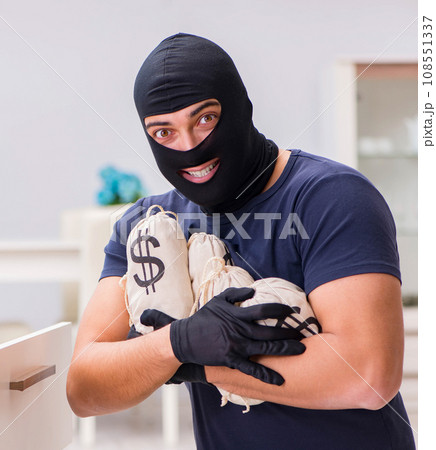 Robber wearing balaclava stealing valuable things Robber wearing balaclava stealing valuable things 108551337