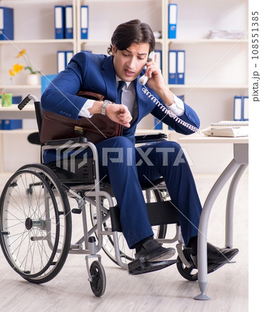 Young male employee in wheelchair working in the office Young male employee in wheelchair working in the office 108551385