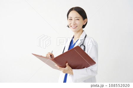 書類を書く女性の医者のポートレート　白背景　カメラ目線 108552020