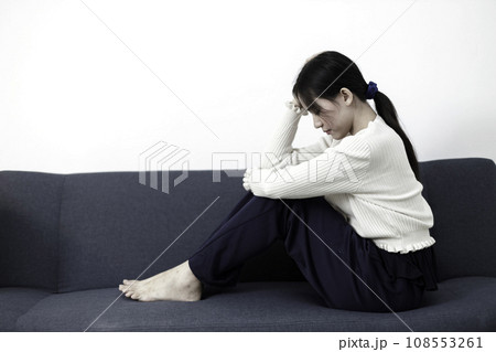 Female having depression sitting alone on sofa. woman headache unhappy emotion. 108553261