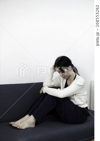 Female having depression sitting alone on sofa. woman headache unhappy emotion. 108553262