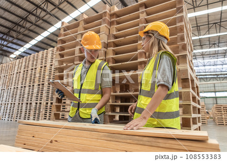 Team engineer carpenter wearing safety uniform and hard hat working holding clipboard. Team engineer carpenter wearing safety uniform and hard hat working holding clipboard. 108553383