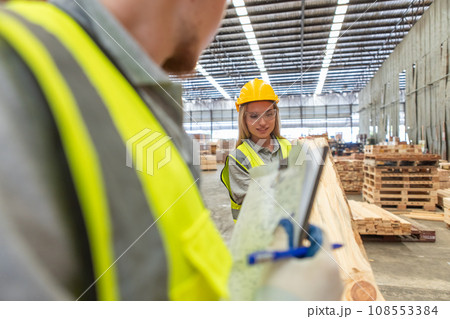 Team engineer carpenter wearing safety uniform and hard hat working holding clipboard Team engineer carpenter wearing safety uniform and hard hat working holding clipboard 108553384