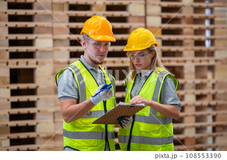 Team engineer carpenter wearing safety uniform and hard hat working holding clipboard Team engineer carpenter wearing safety uniform and hard hat working holding clipboard 108553390