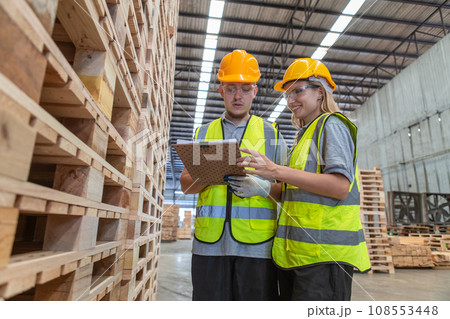 Team engineer carpenter wearing safety uniform and hard hat working holding clipboard Team engineer carpenter wearing safety uniform and hard hat working holding clipboard 108553448
