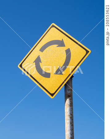 道路標識(警戒標識)「ロータリーあり」と青空。(縦構図) 道路標識(警戒標識)「ロータリーあり」と青空。(縦構図) 108553621