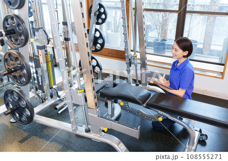 スポーツジムのトレーニングマシンを点検する女性スタッフ 108555271