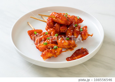 deep fried Korean rice cake (Tteokbokki) skewered with spicy sauce deep fried Korean rice cake (Tteokbokki) skewered with spicy sauce 108556546