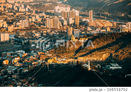 Tbilisi Georgia. Residential Quarters time . time elevated view Cityscape Famous Landmarks: Kartlis Deda Georgia mother Monument, Narikala Fortress, Tabor Monastery In Evening sunset Tbilisi Georgia. Residential Quarters time . time elevated view Cityscape Famous Landmarks: Kartlis Deda Georgia mother Monument, Narikala Fortress, Tabor Monastery In Evening sunset 108558702