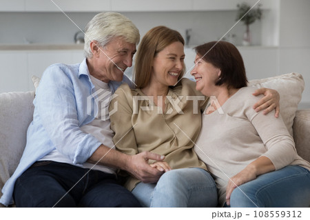 Happy adult daughter enjoying meeting with senior parents at home 108559312