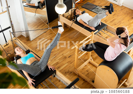 Group of women doing exercises during pilates reformer class 108560188