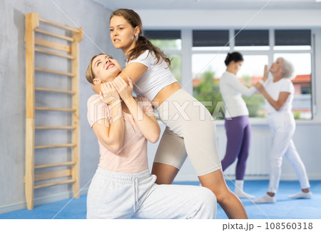 Two young women training self-defense techniques Two young women training self-defense techniques 108560318