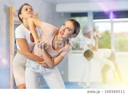 Woman trying to break free of grip and striking chin with elbow in self defense training Woman trying to break free of grip and striking chin with elbow in self defense training 108560511
