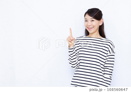 白い背景の前で人差し指を立てる40代の女性 白い背景の前で人差し指を立てる40代の女性 108560647