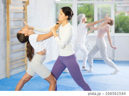 Asian woman practicing palm strike to chin in sparring at self-defense course Asian woman practicing palm strike to chin in sparring at self-defense course 108561584