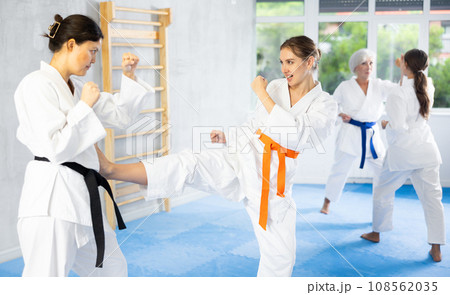Young woman practicing karate kicking techniques during training sparring 108562035