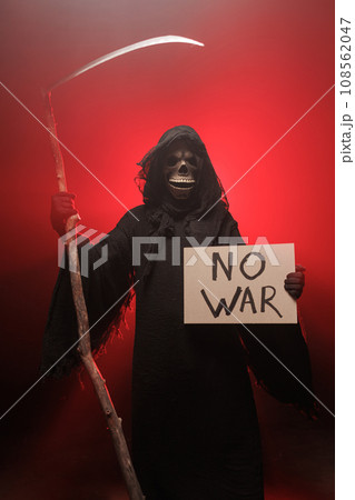 The Grim Reaper holds a poster with the inscription no war. The scary grim reaper. Death Grim Reaper 108562047